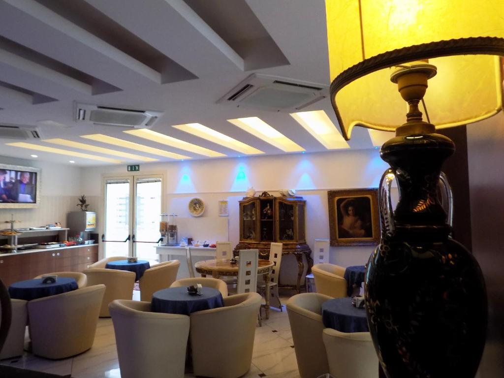 a room with chairs and a table and a lamp at Hotel Residence Villa Del Mare in Rimini