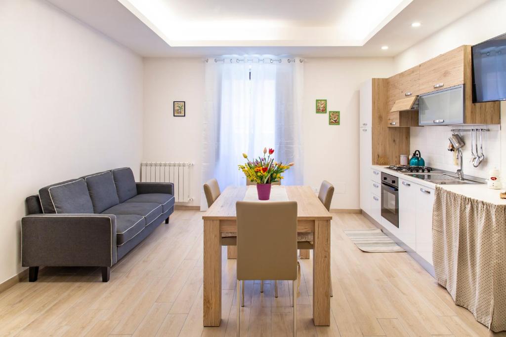 eine Küche und ein Wohnzimmer mit einem Tisch und einem Sofa in der Unterkunft Le casette di nonno Pippo in Palazzolo Acreide