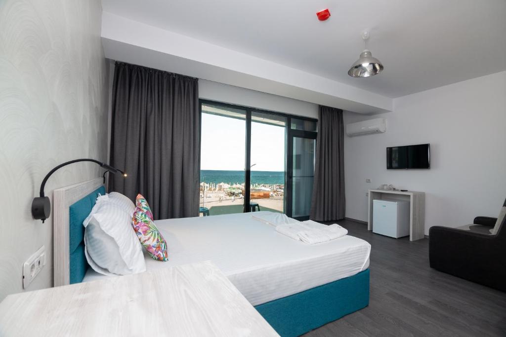 a hotel room with a bed and a view of the ocean at Hotel H in Eforie Nord