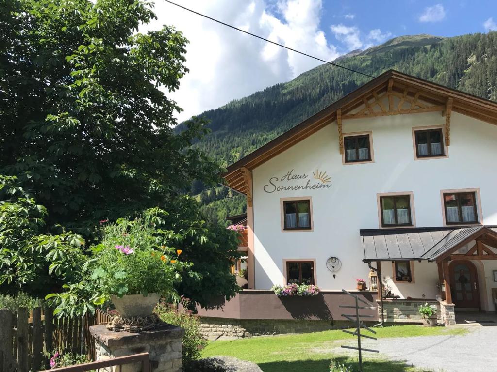 un gran edificio blanco con montañas en el fondo en Apart Sonnenheim en Kaunertal