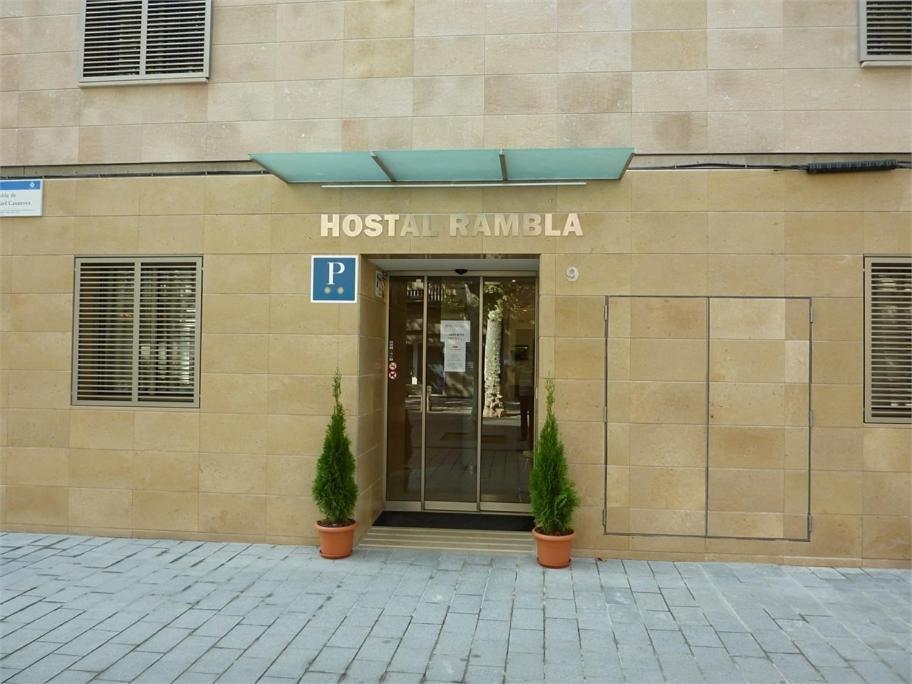 a hospital building with two plants in front of it at Hostal Rambla in Sant Boi del Llobregat