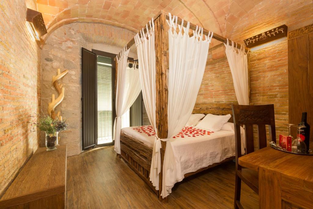 
a bedroom with a large bed and a large window at Hotel Històric in Girona
