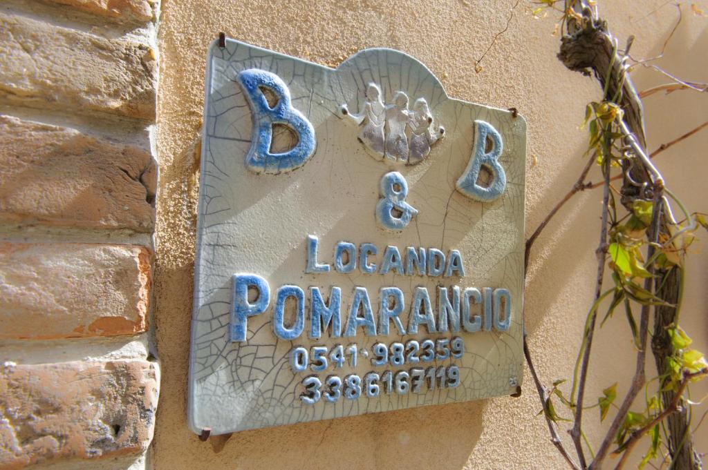 un cartello sul lato di un edificio di Pomarancio BnB a Mondaino
