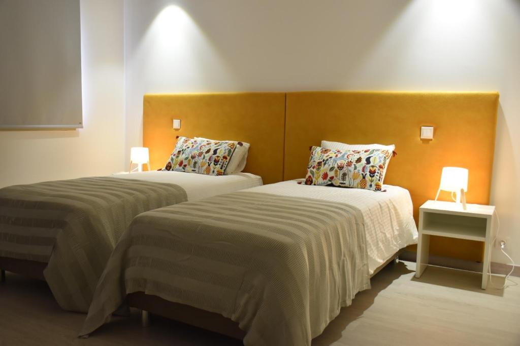 two beds in a hotel room with two lamps at Varandas do Mosteiro in Batalha