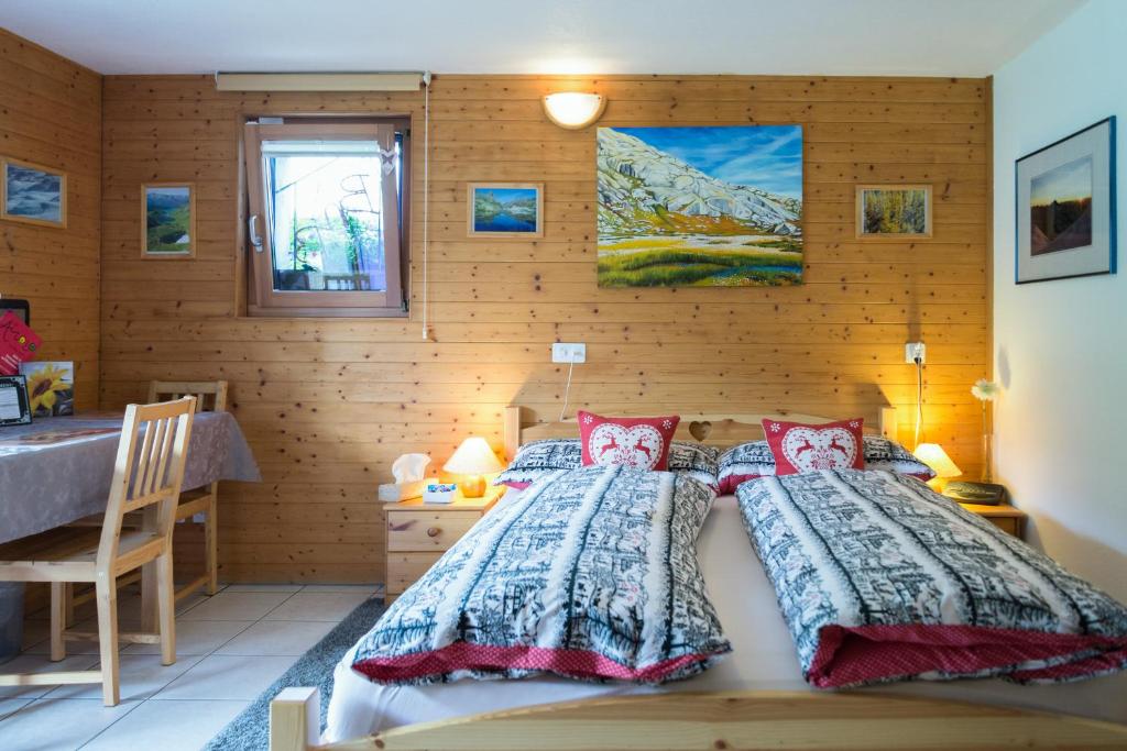 a bedroom with a bed and a wooden wall at B&B Gottardo in Airolo
