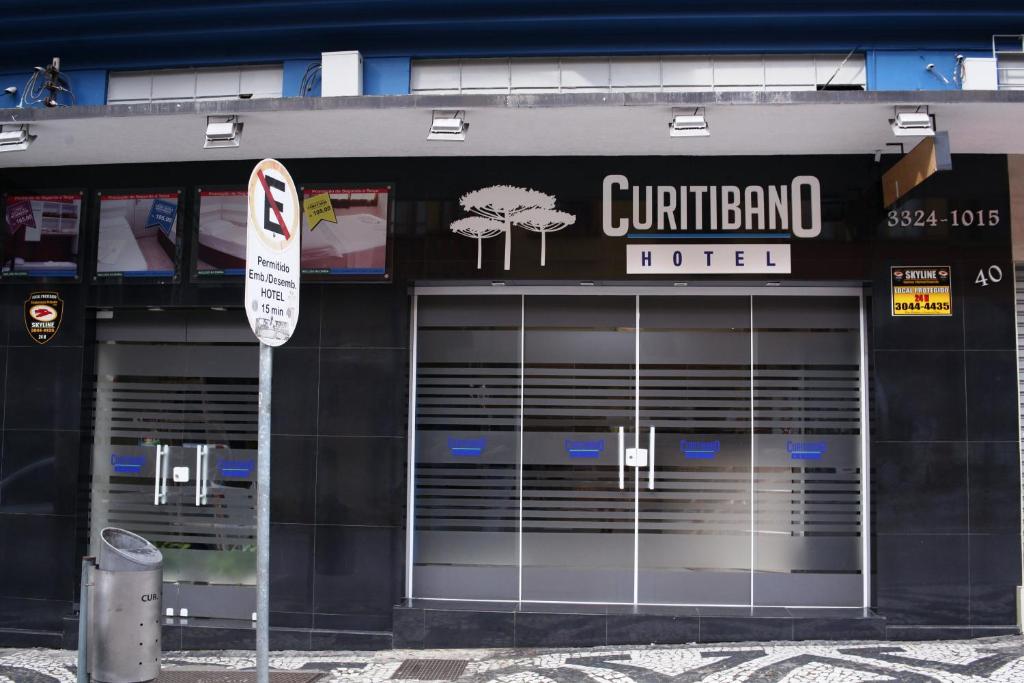 a building with two garage doors and a sign at Hotel Curitibano in Curitiba