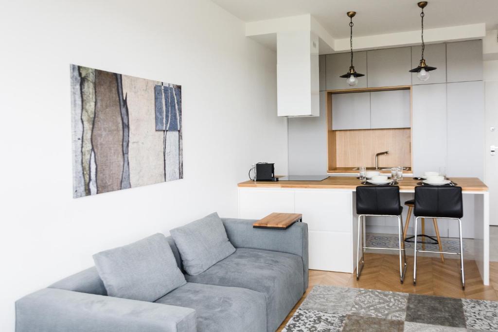 a living room with a couch and a kitchen at LuxLux Apartments Silver Dove in Warsaw