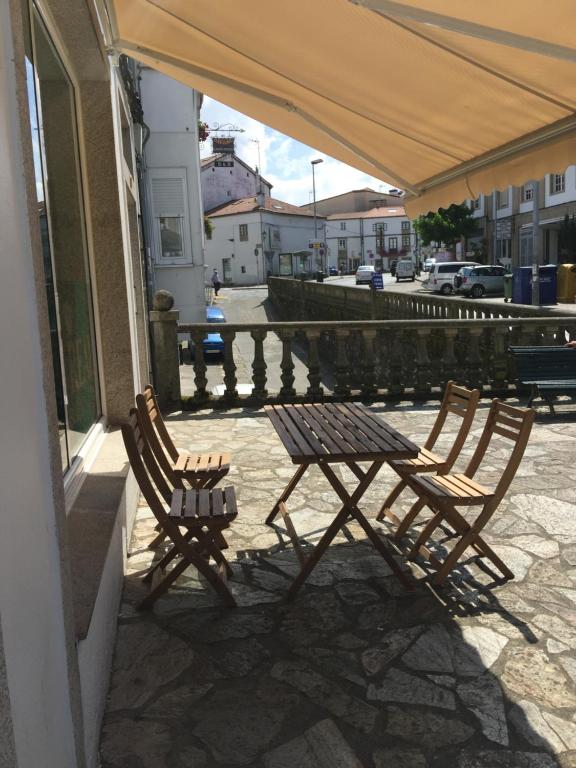 dwa drewniane krzesła i stół na patio w obiekcie Albergue Porta Real NO BIKE STORAGE w Santiago de Compostela