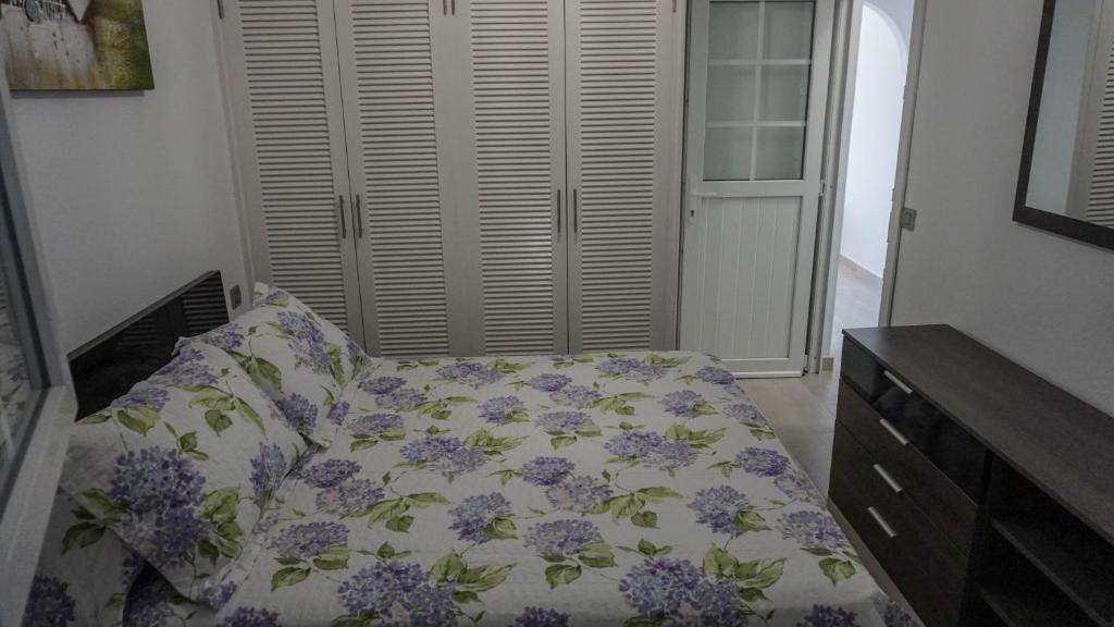 プエルト・デル・カルメンにあるApartment Old Town Reina Sofia 3のベッドルーム1室(紫色の花のベッド1台付)