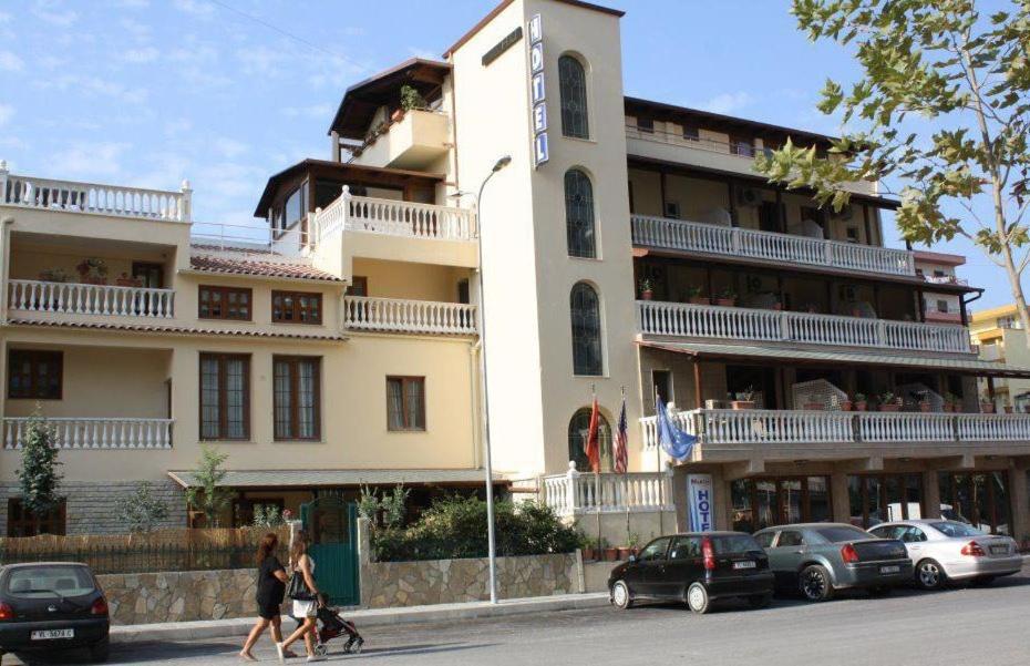 a large building with cars parked in front of it at Hotel Martini in Vlorë