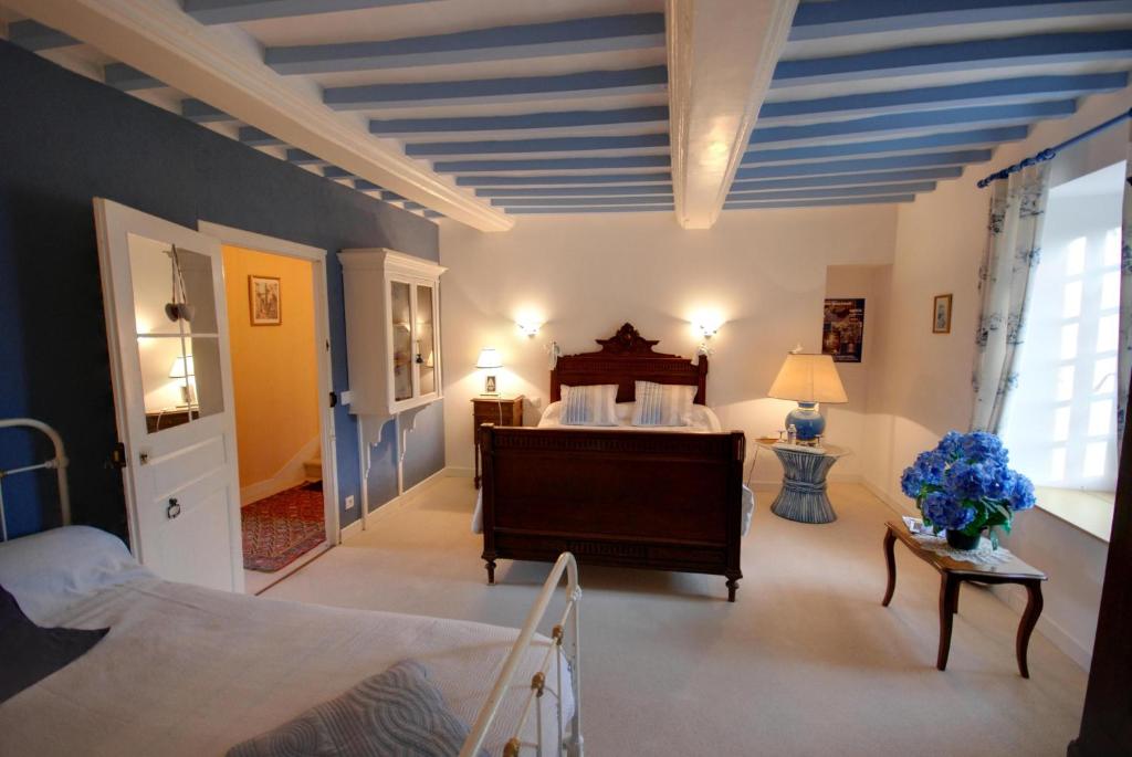 sypialnia z łóżkiem w pokoju z niebieskim sufitem w obiekcie La Faisanderie w mieście Grandcamp-Maisy