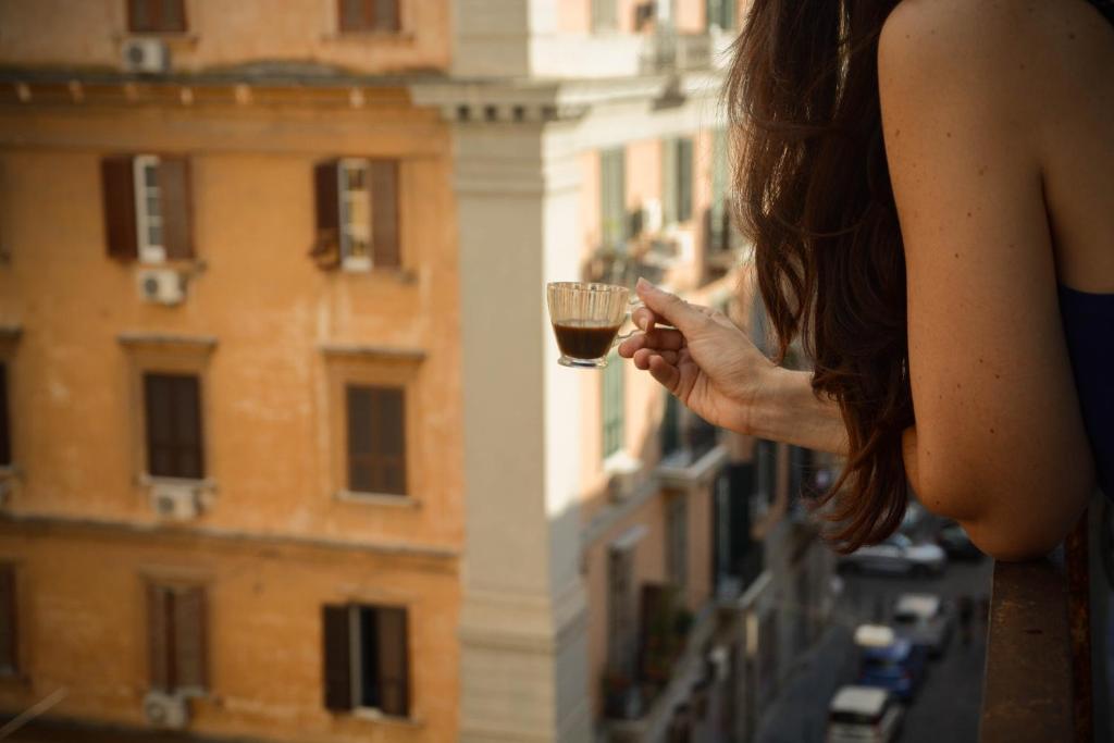 a woman holding a glass of wine on a balcony at Casa Niccolò in Naples