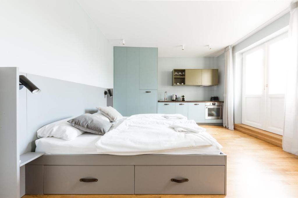 - une chambre avec un grand lit et des draps blancs dans l'établissement Sunny Riverside Apartments, à Prague