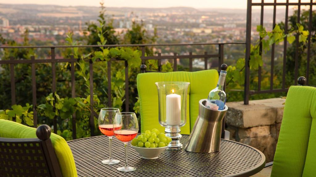 uma mesa com copos de vinho e uma vela na varanda em Traumhafte Ferienwohnung im Luisenhof em Dresden