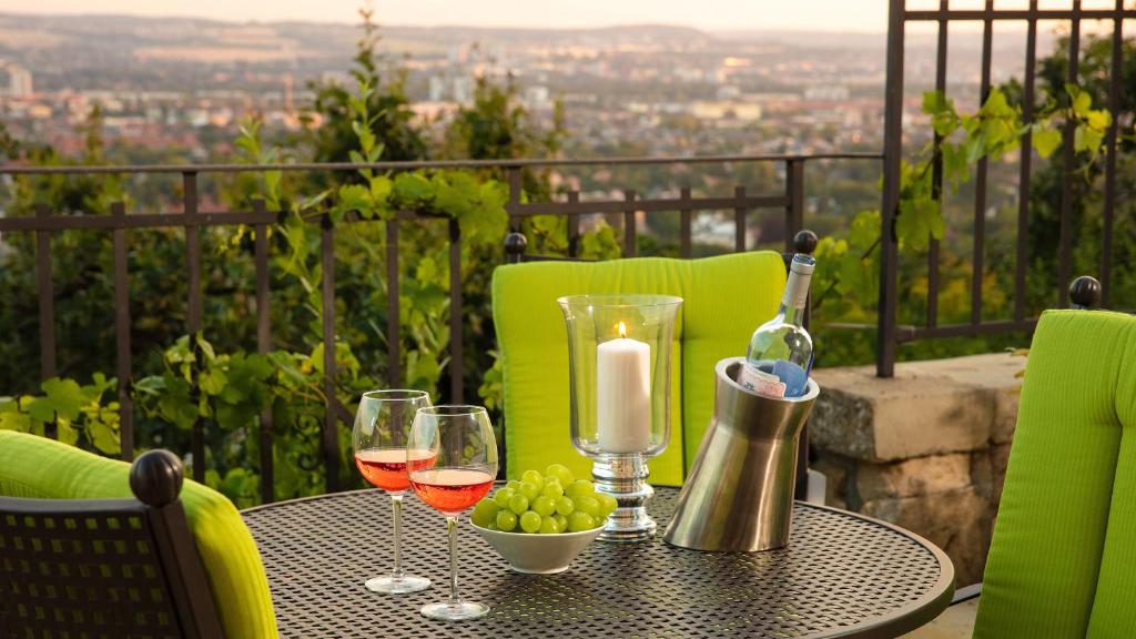 una mesa con copas de vino y una vela en el balcón en Traumhafte Ferienwohnung im Luisenhof, en Dresden
