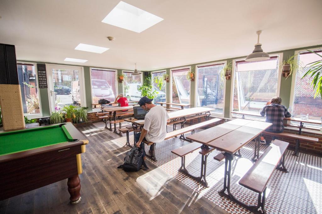 a man standing in a restaurant with a pool table at Palmers Lodge Swiss Cottage in London