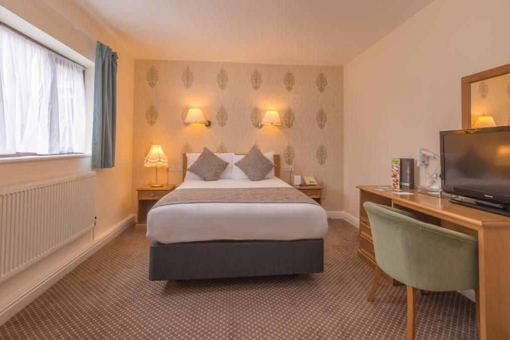 um quarto de hotel com uma cama e uma televisão de ecrã plano em Bridge House Hotel em Birmingham