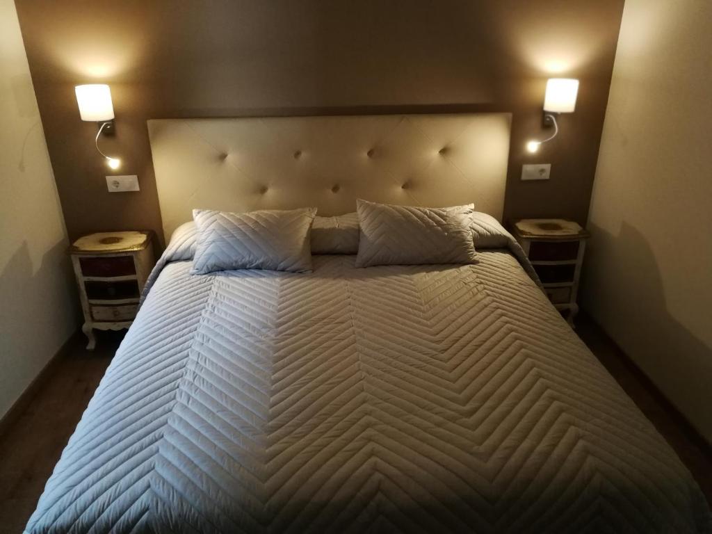 um quarto com uma cama grande com duas luzes em Hostal Casa Lacreu em Sahun