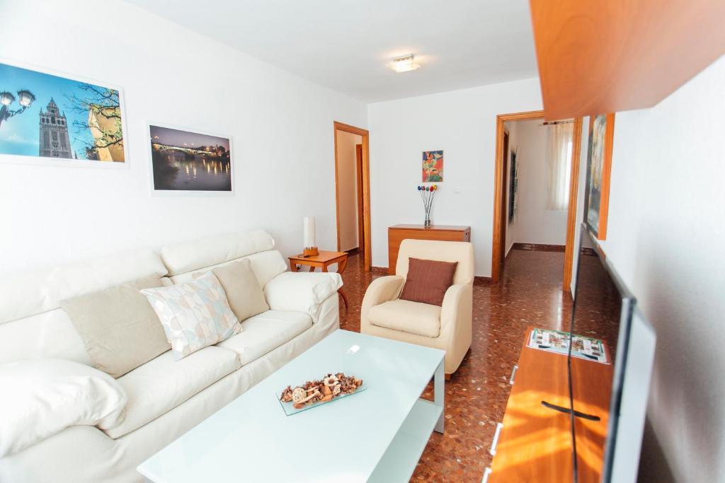 een woonkamer met een witte bank en een tafel bij Comfortable- 2Bd 1Bth- Triana in Sevilla