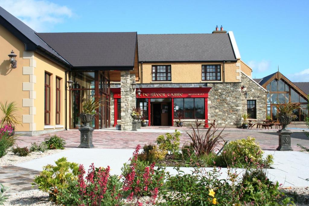 a building with a courtyard with flowers at Silver Tassie Hotel & Spa in Letterkenny
