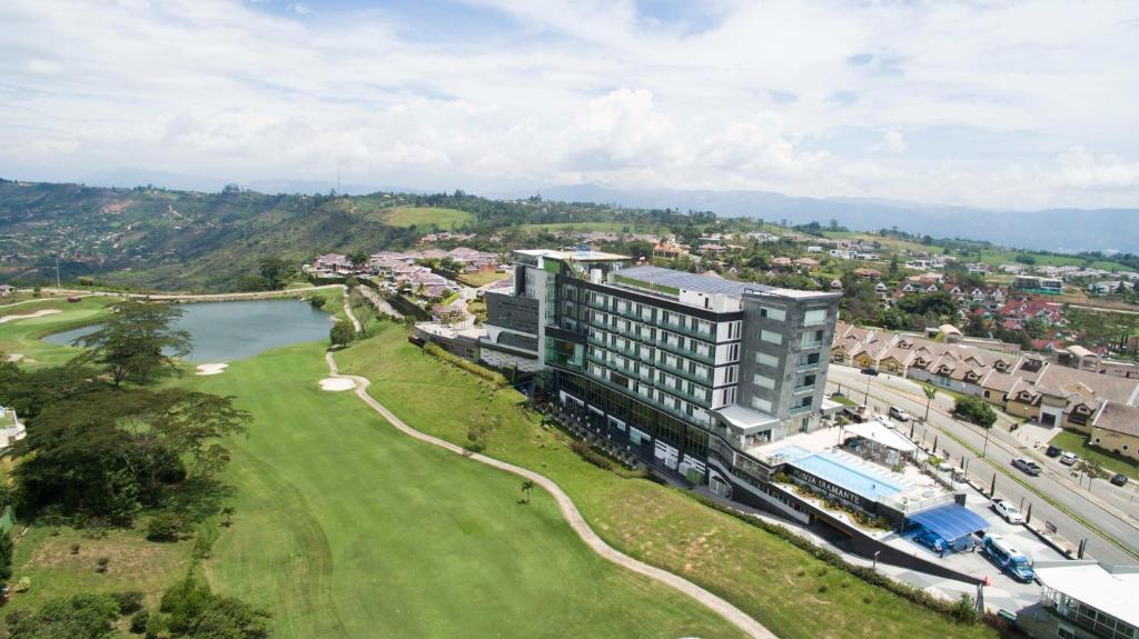 - une vue aérienne sur un bâtiment et un parcours de golf dans l'établissement Punta Diamante Premium Hotel, à Bucaramanga