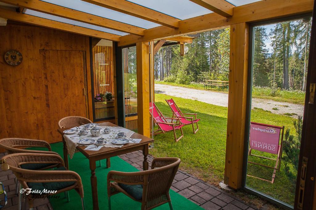 eine Terrasse mit einem Tisch und Stühlen auf einer Veranda in der Unterkunft Ferienwohnung Moser in Mariapfarr
