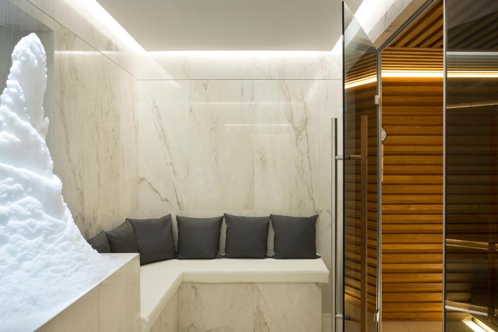 a bathroom with a bench with two pillows at Hôtel Barrière Le Majestic Cannes in Cannes