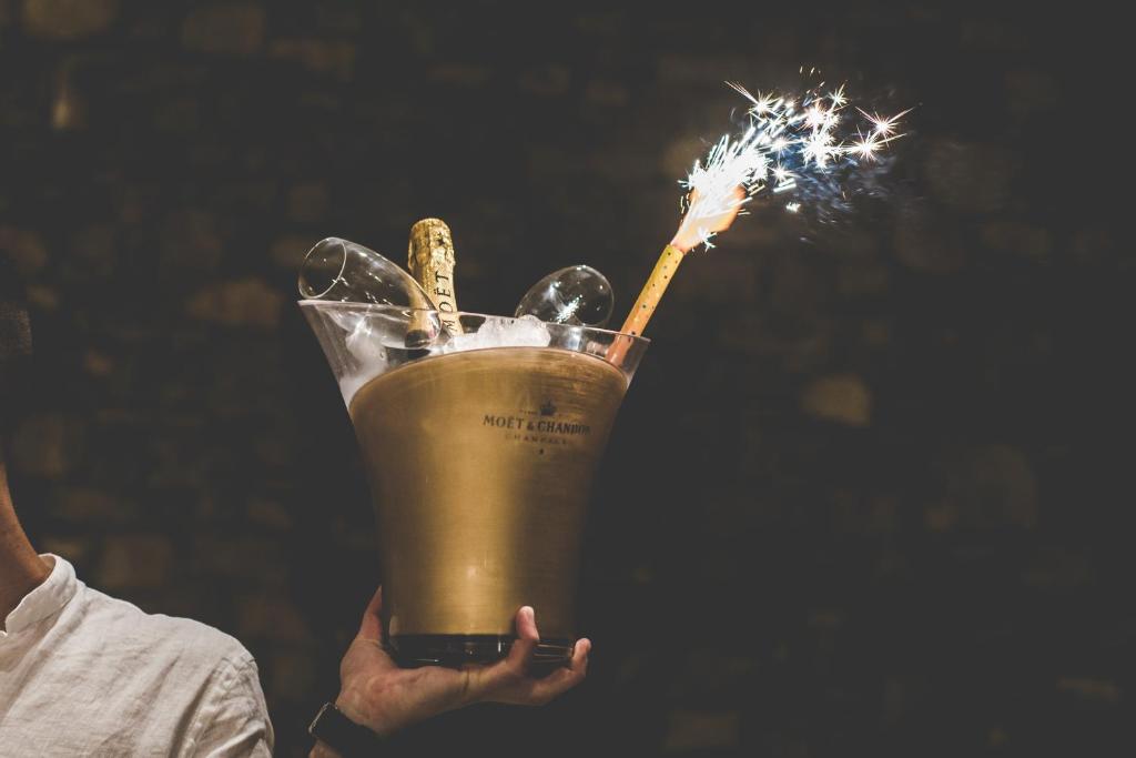 a person holding a drink with a sparkler in it at Super Paradise Hotel in Super Paradise Beach