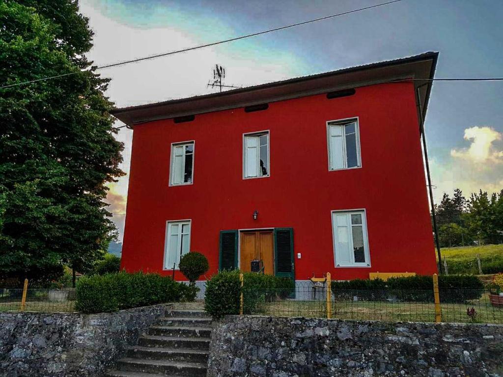 una casa roja con escaleras delante en Il Tiglio, en Monsagrati