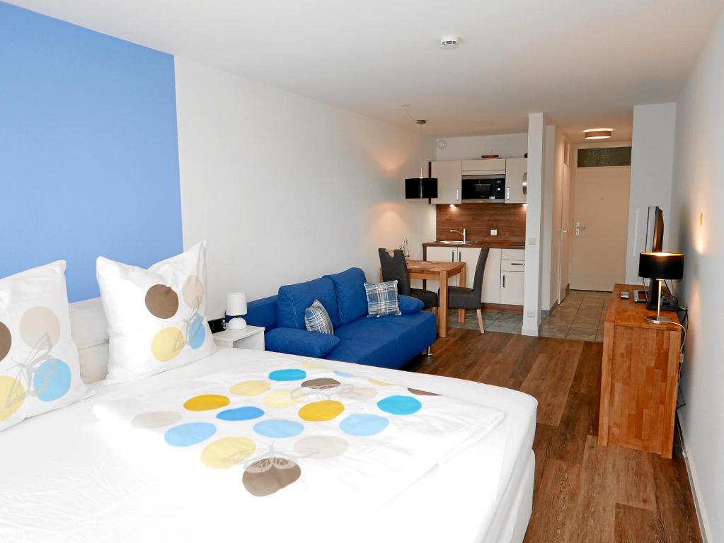 a bedroom with a large bed and a blue couch at Apartment Möwe in Meersburg