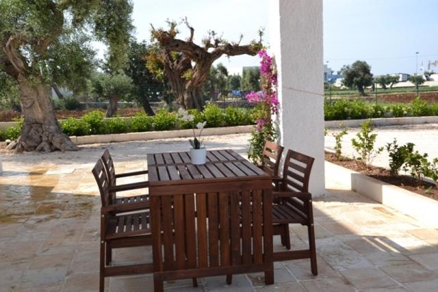 a wooden table and chairs with a potted plant on it at case per vacanze torre incina in Polignano a Mare