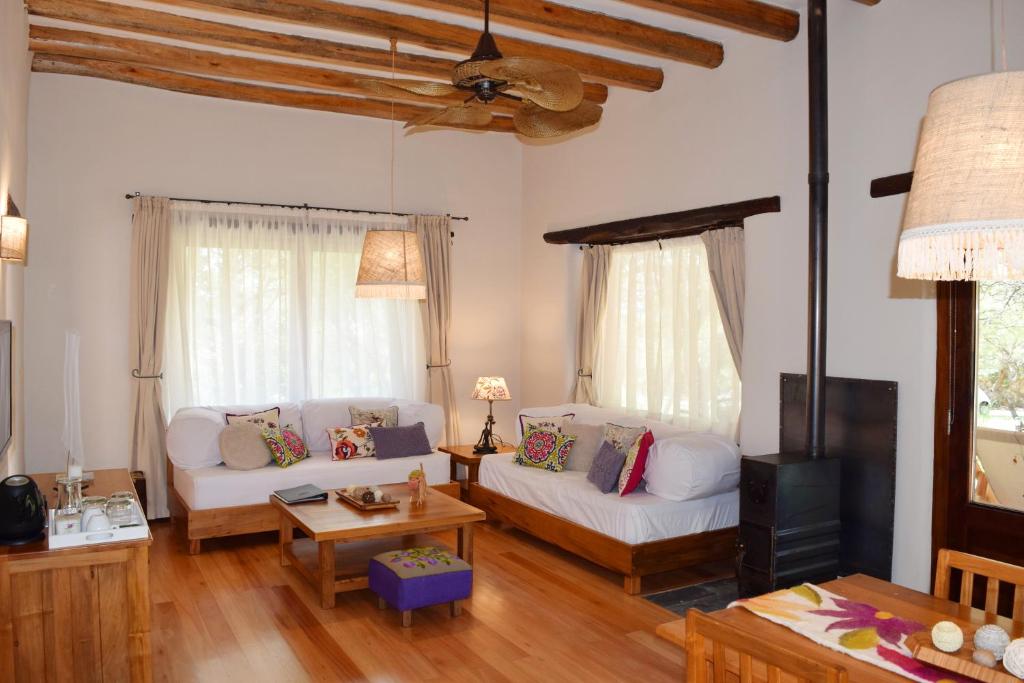 sala de estar con 2 sofás blancos y TV en Las Dalias en Villa Las Rosas