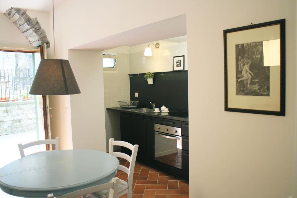 a kitchen with a table and a dining room at Holiday House Alla Torre in Mandello del Lario