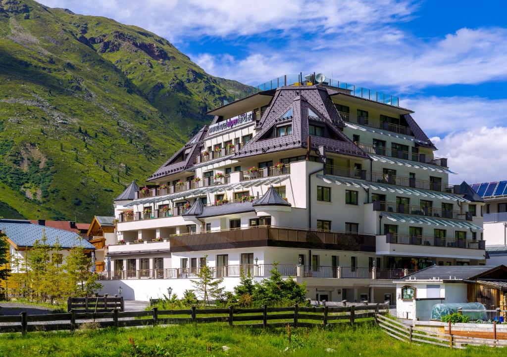 a large building in front of a mountain at Hotel Alpenland in Obergurgl
