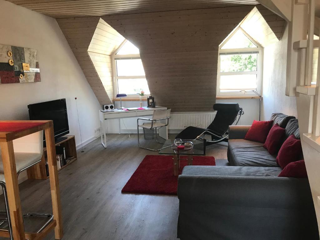 ein Wohnzimmer mit einem Sofa und 2 Fenstern in der Unterkunft Appartement Ginstertraum in Lüneburg