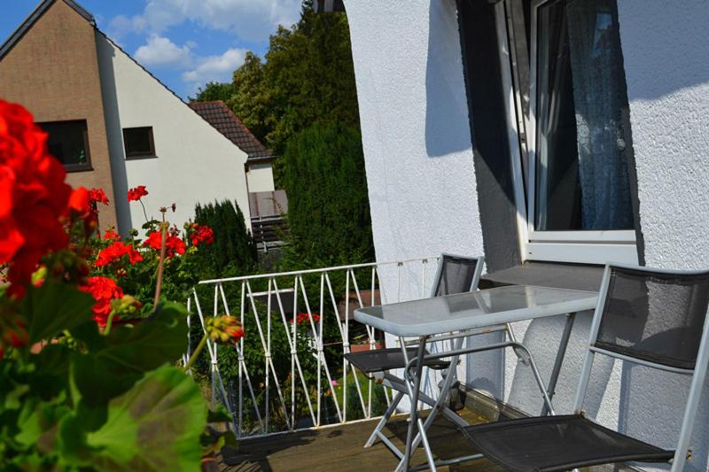 a balcony with a table and chairs and flowers at Hotel Hohenstein -Radweg-Messe-Baldeneysee in Essen