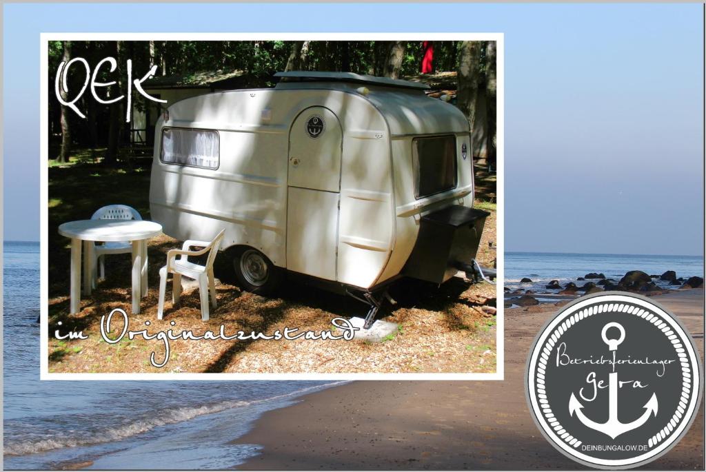 a silver trailer sitting on the beach next to the ocean at DDR Wohnwagen QEK direkt am Strand in Dranske