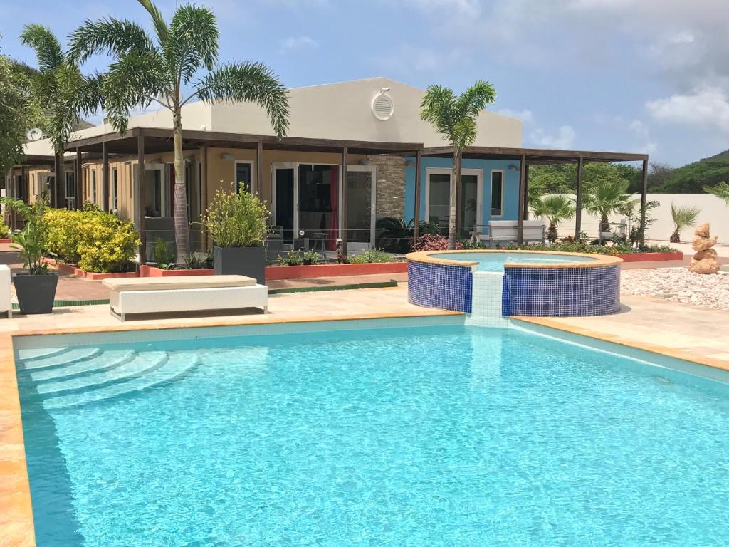 a swimming pool in front of a house at Malika Apartments in Westpunt