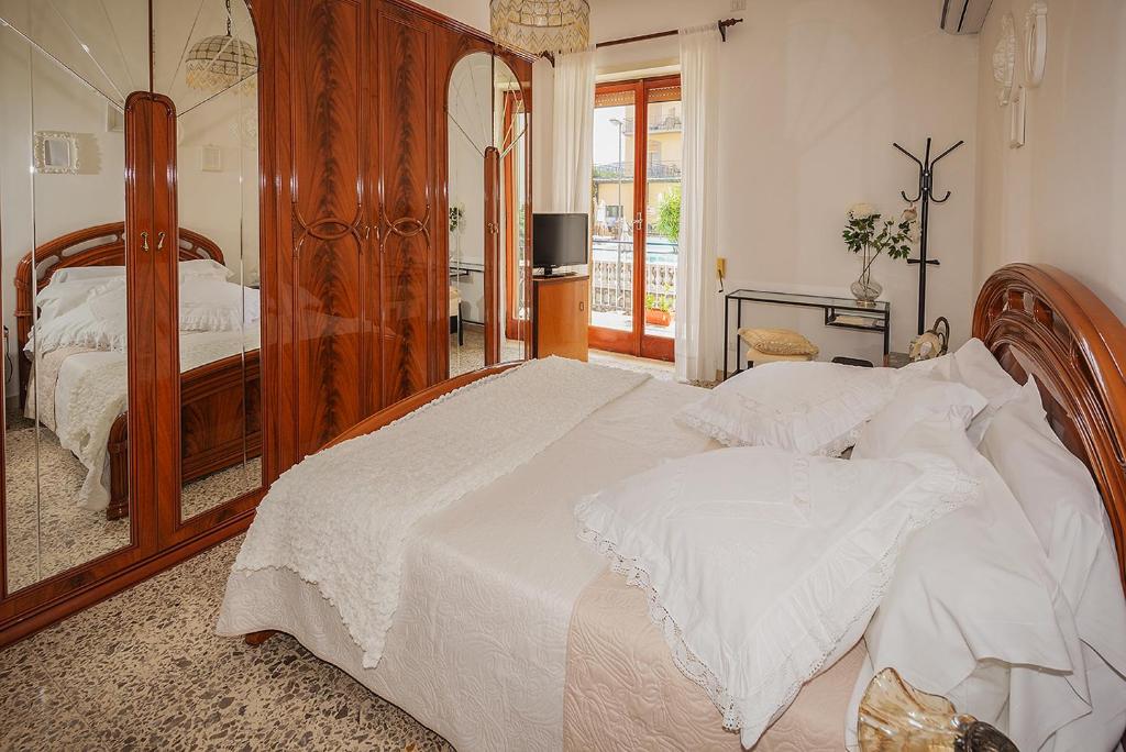 - une chambre avec un grand lit en bois et un miroir dans l'établissement Casa Rosetta, à Sorrente