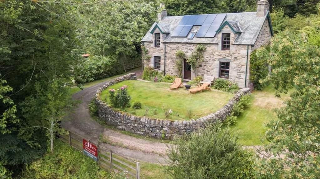 una vista aérea de una casa con una pared de piedra en The Ferry House Cottage en Aberfeldy