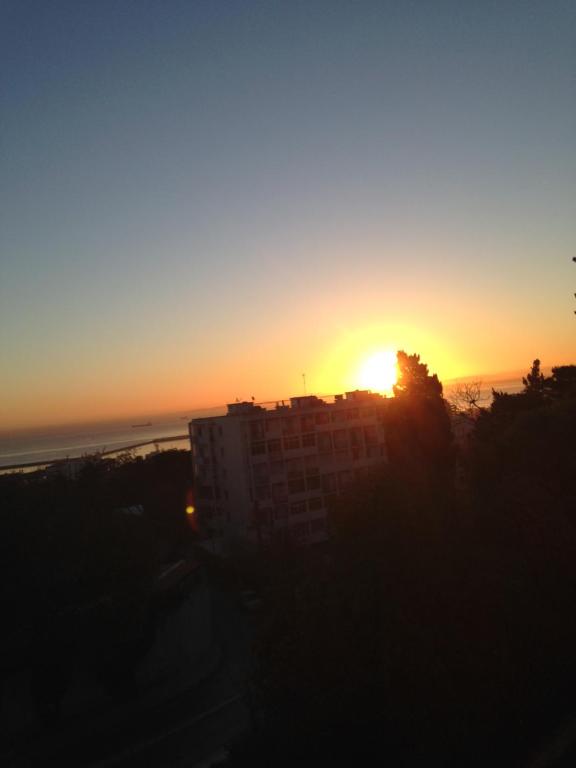 un tramonto su un edificio e sull'oceano di El Jenina Apartment a Alger