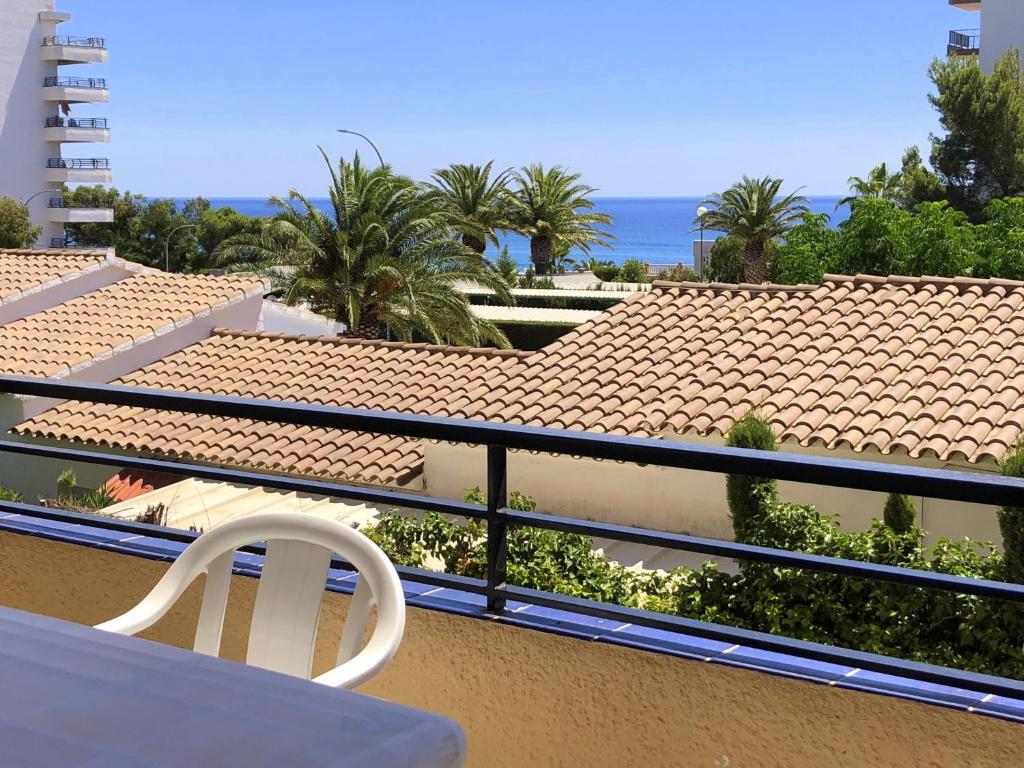 Un balcón con una silla blanca y vistas al océano. en Rentalmar Margarita, en Miami Platja