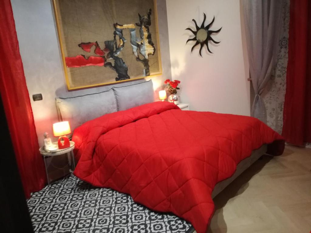 a red bed with a red comforter in a bedroom at The Orange Groove in Bari