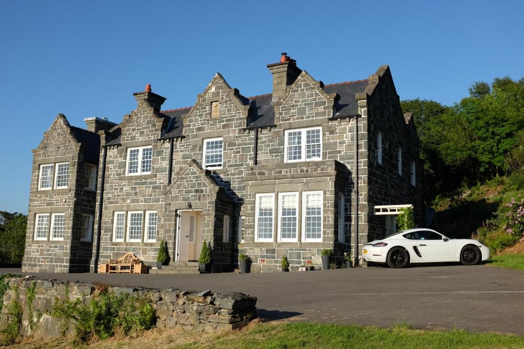 a white car parked in front of a building at Crown Lodge in Harlech