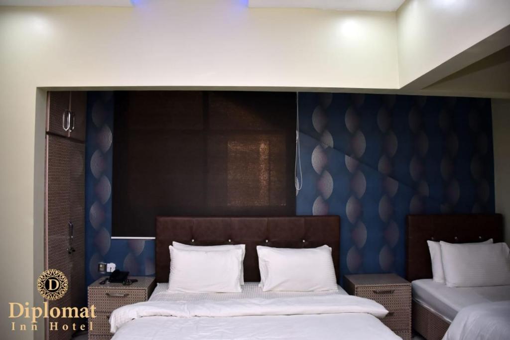 Giường trong phòng chung tại Diplomat Inn Hotel