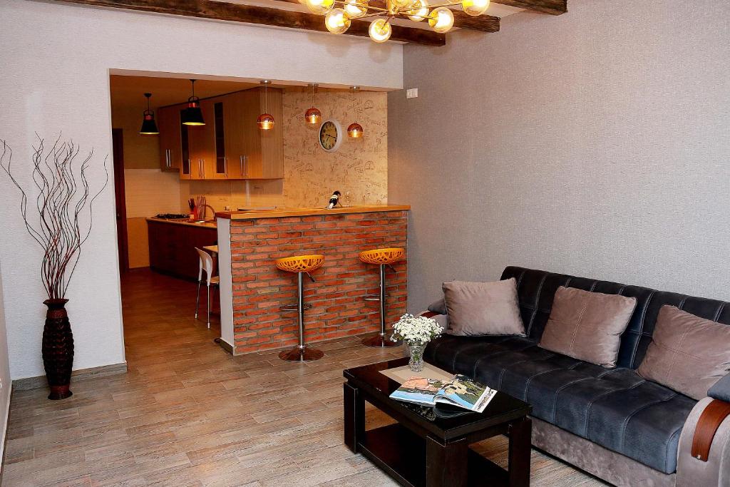 Una sala de estar con un sofá y una cocina. en Tbilisi Trinity Apartment, en Tiflis