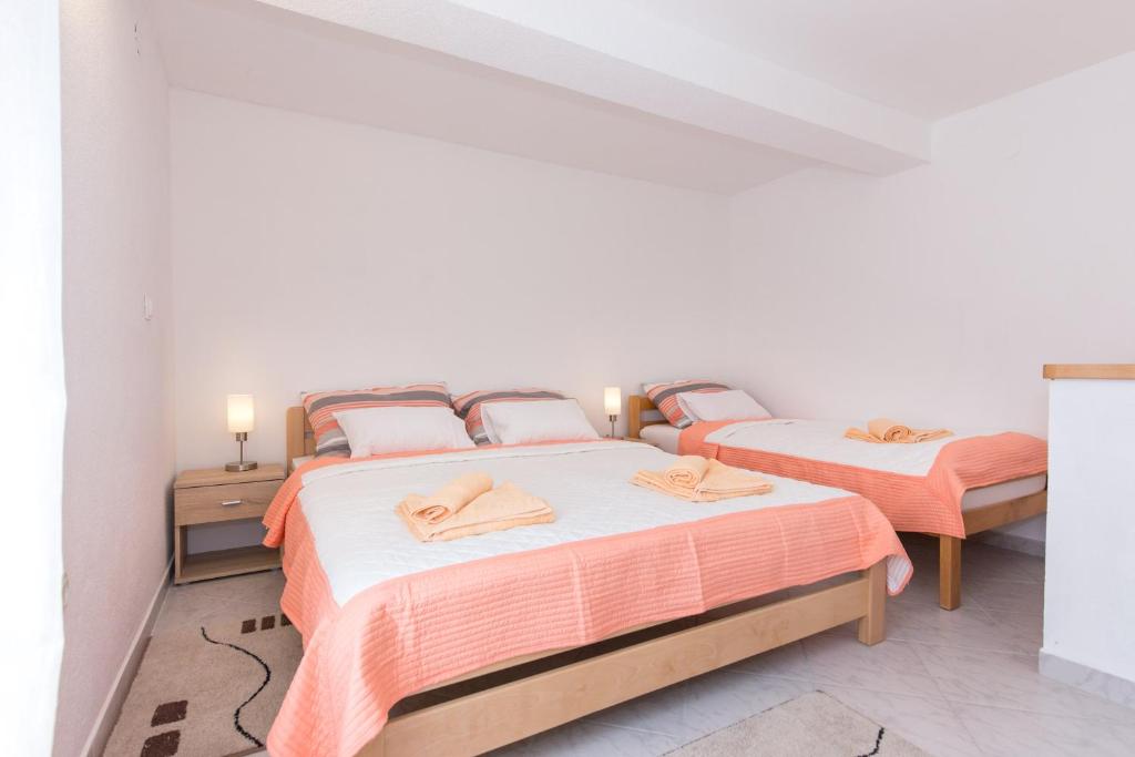 2 Betten in einem Zimmer mit weißen Wänden in der Unterkunft Apartman Marija 218 in Risika