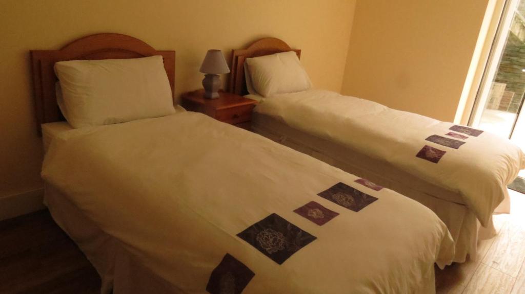 dos camas sentadas una al lado de la otra en una habitación en Rossa House, en Rosscarbery