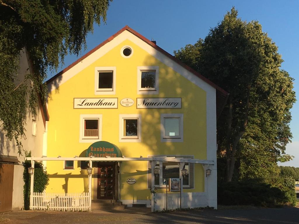 un edificio amarillo con un cartel en el costado en Landhaus Nauenburg en Heere