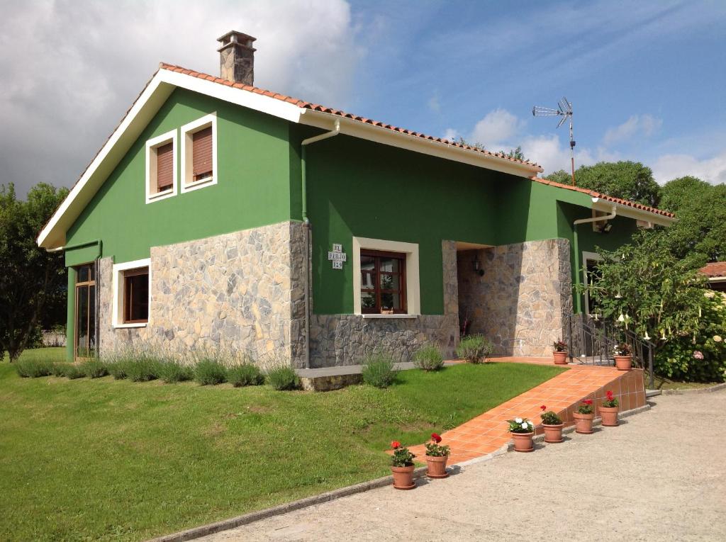una casa verde con macetas delante de ella en Casa Rural El FerJo, en Colunga